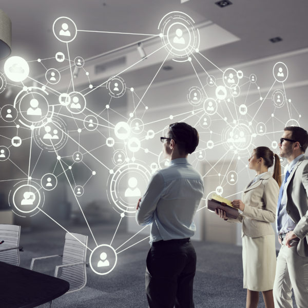 Social networking technologies . Mixed media Young businesspeople in office interior and social net concept. Mixed media