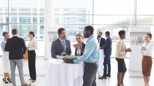 Business people discussing over documents at table during a seminar